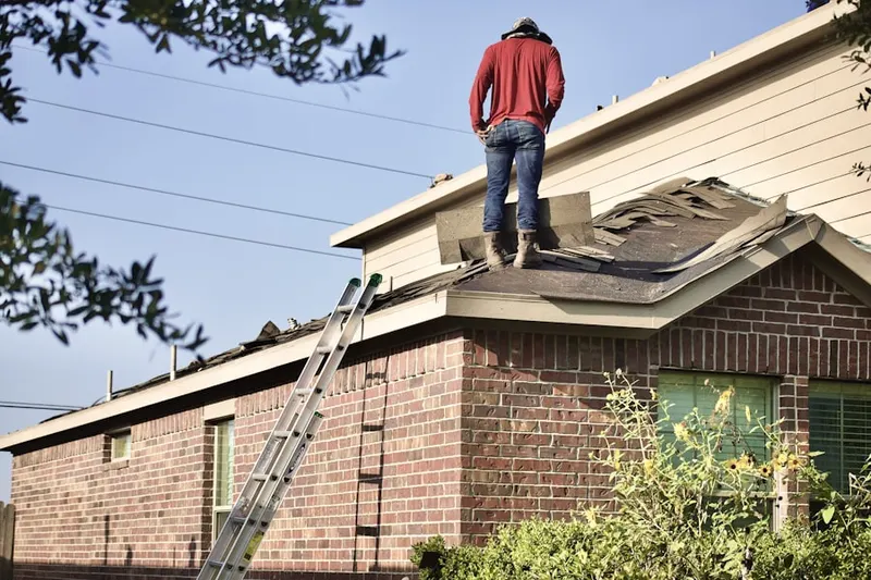 Professional roofer working on a residential roof in Athena
